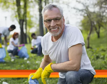 A man works picking up trash in his community