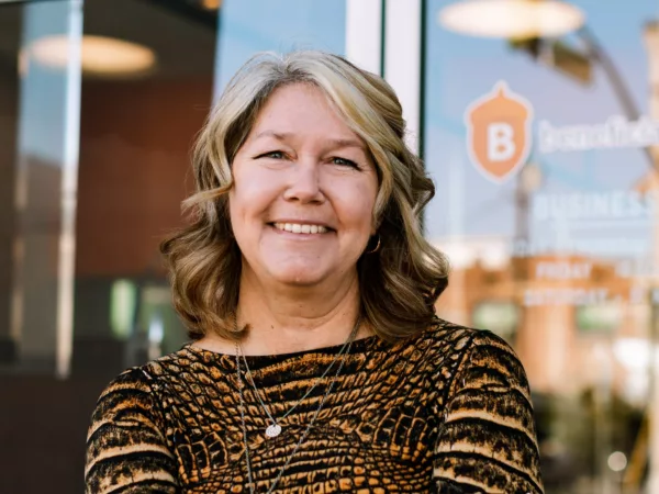 Monique Johnson Headshot, standing in front of a Beneficial State Bank branch