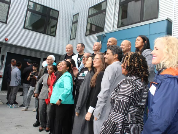 CROP Oakland Grand Opening in March 2023. A line of CROP staff and supporters including Kat Taylor pose for a photo on CROP's campus