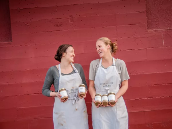 Ground Up Co-founders, Julie and Carolyn, posing with jars of their nut butter.